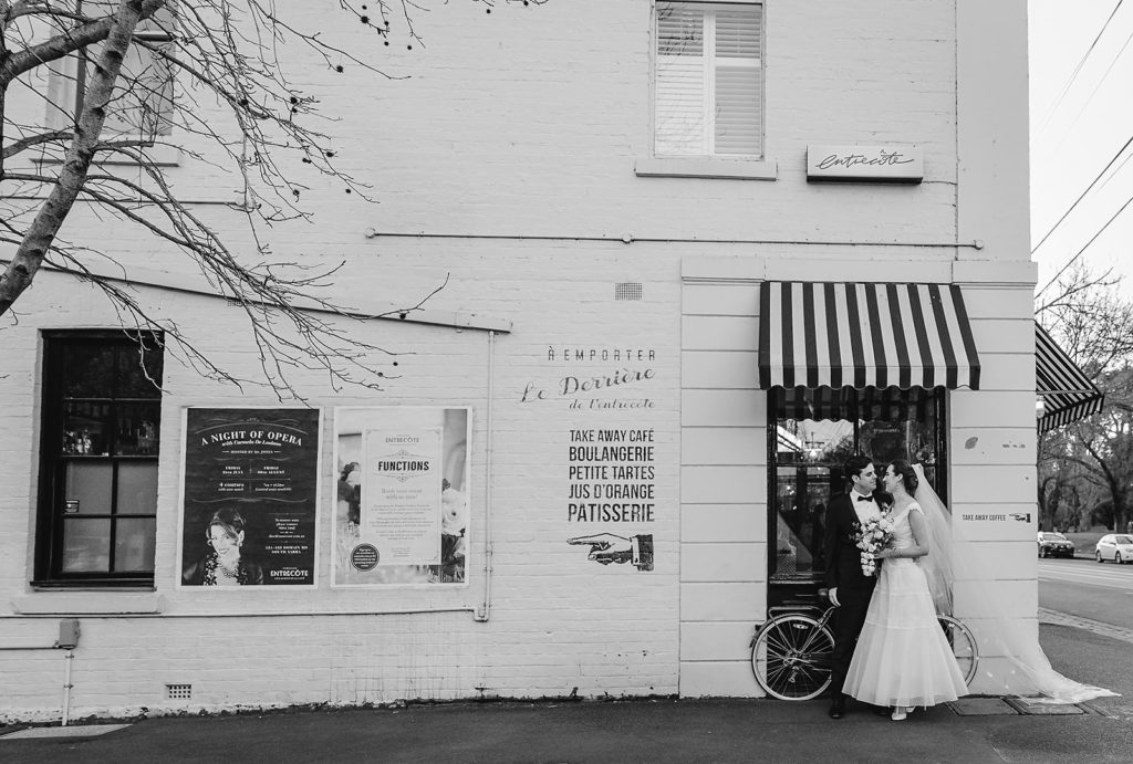 black and white photo of couple getting married in front of cafe